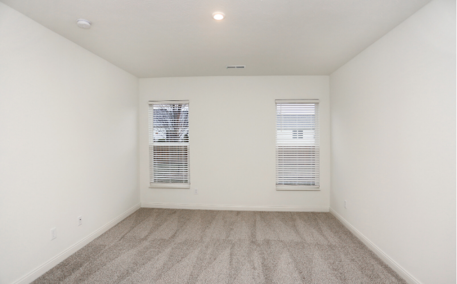 Large bedroom with grey carpet and two windows