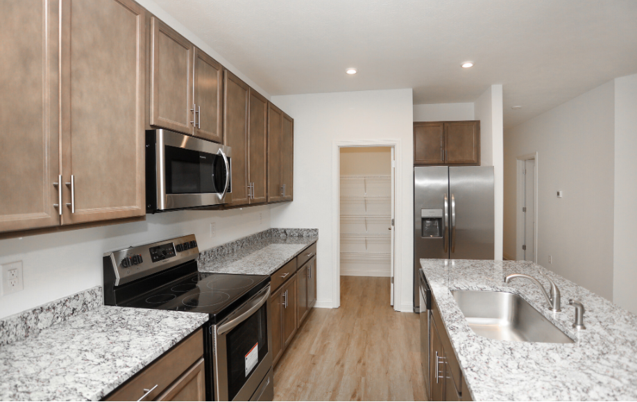 Shows a modern kitchen with a stove, microwave, and refrigerator 