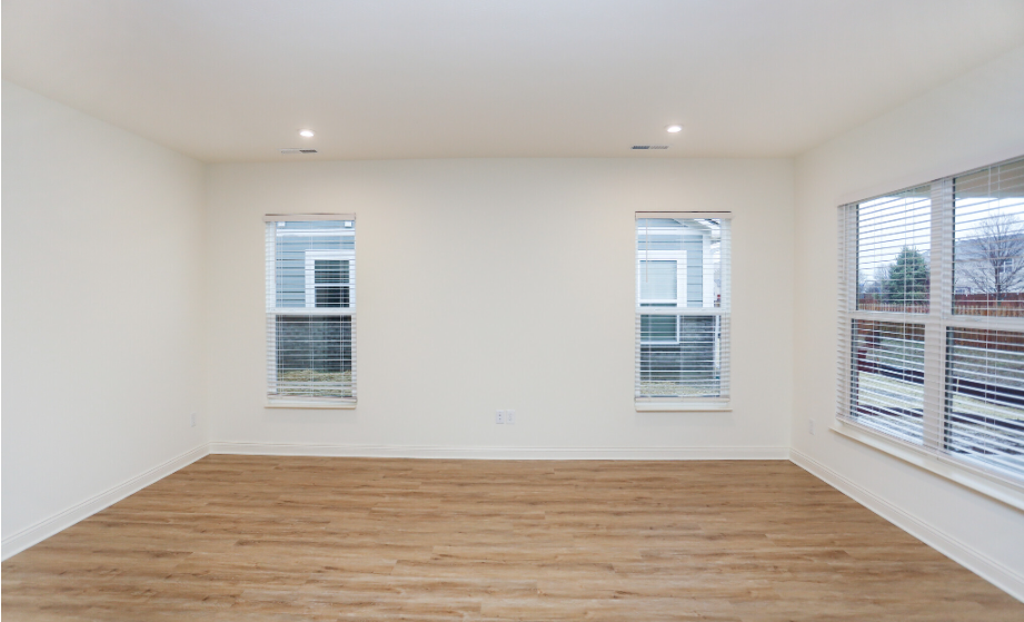Three windows in a living room with wood paneling flooring