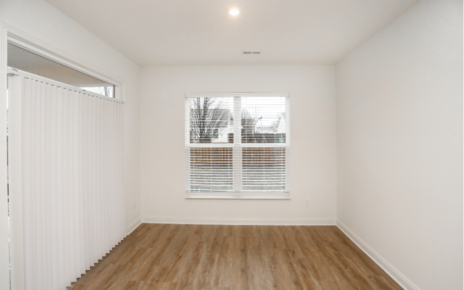 Room with sliding glass door and wood paneling floor