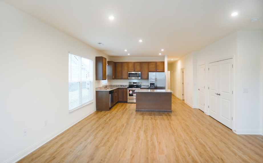 Kitchen and living room. Kitchen has modern amenities and the room has wood flooring