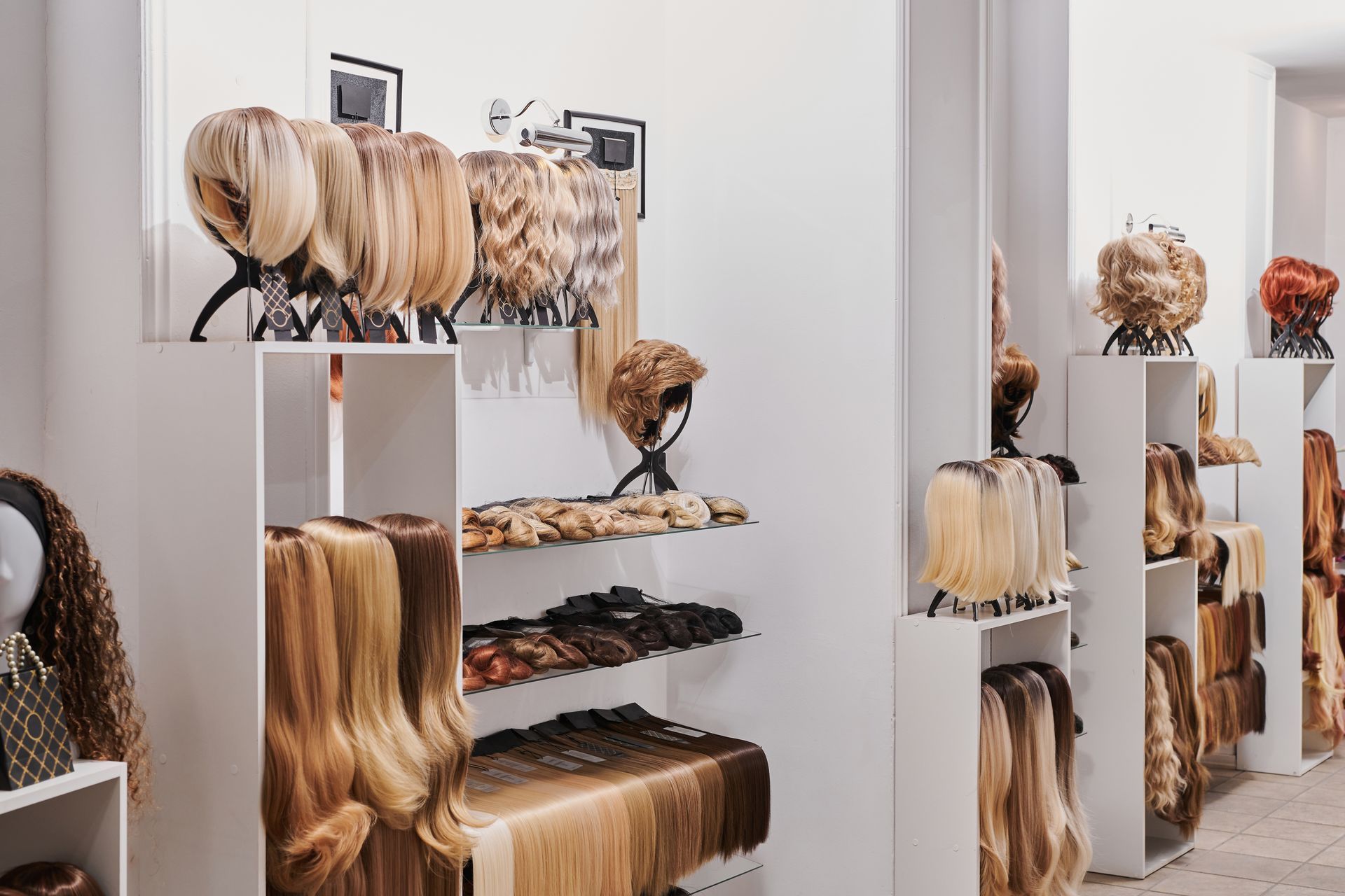 Display of synthetic and human hair wigs in a wig shop showroom