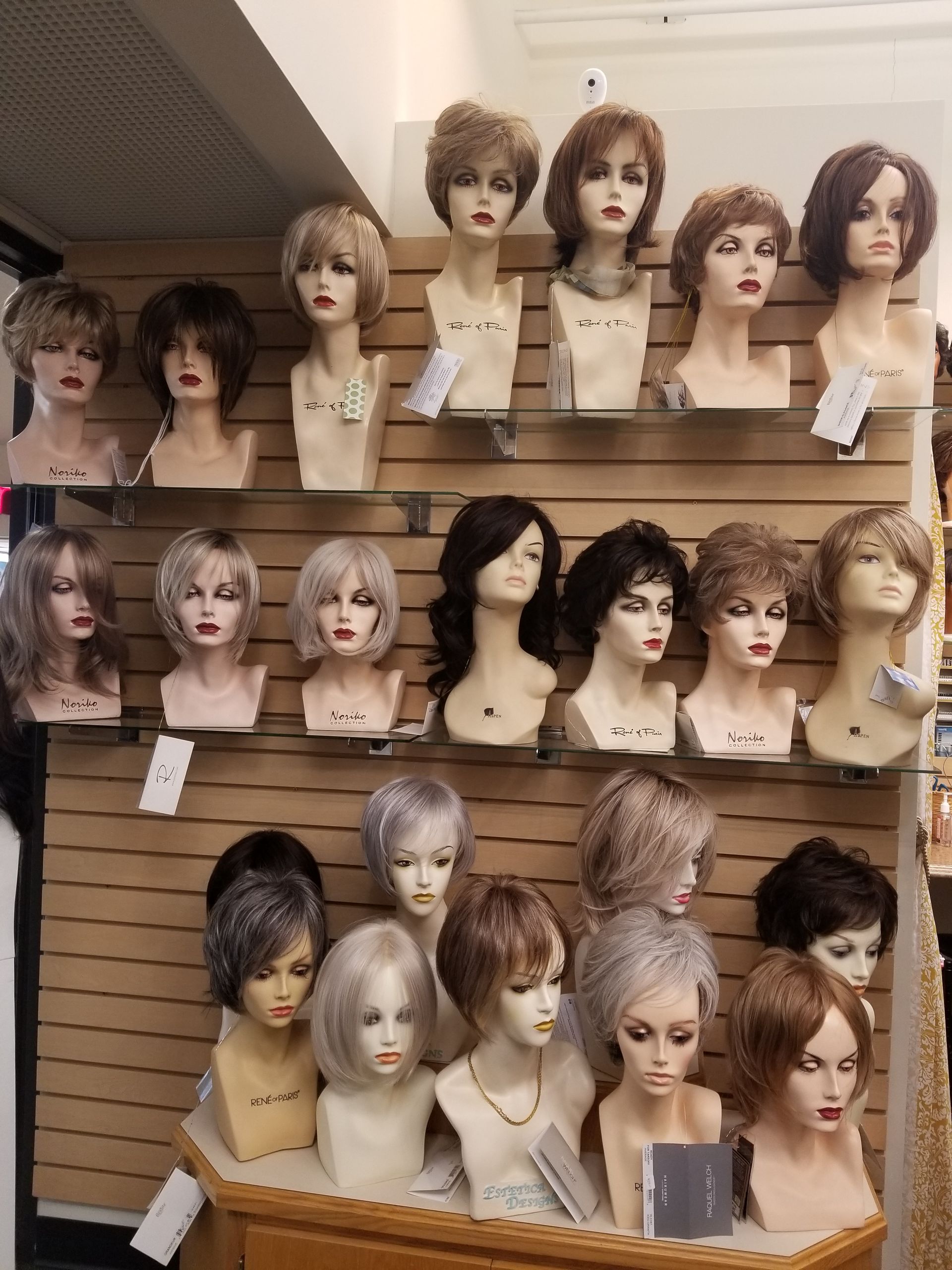 Three mannequin heads with wigs: ombre blonde, brown bob, and long brown. Three mannequin heads with wigs: ombre blonde, brown bob, and long brown.