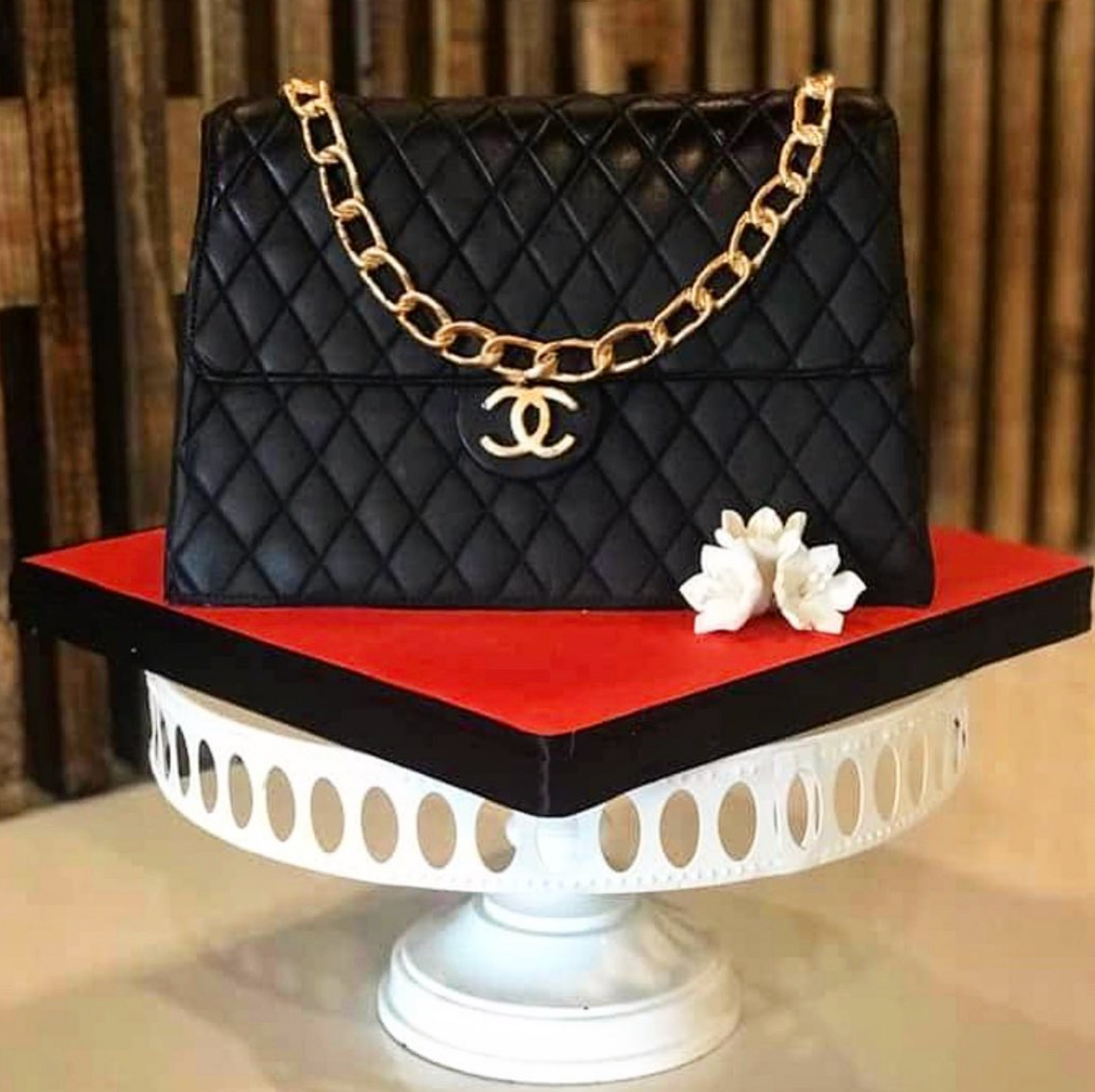 A cake in the shape of a black chanel purse