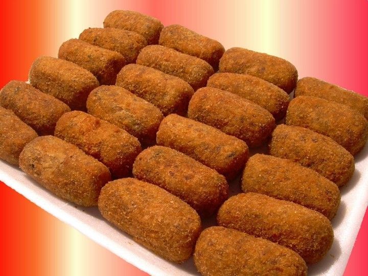 A white plate filled with fried food on a red background