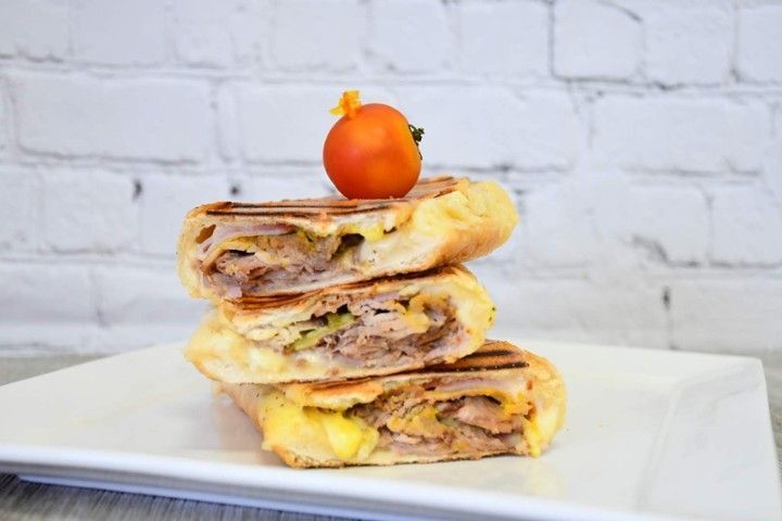 A sandwich is stacked on top of each other on a white plate.