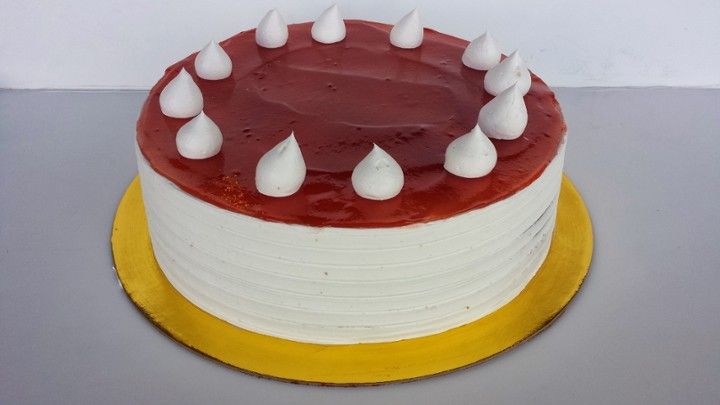 A red velvet cake with white frosting on a gold plate