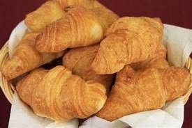 A basket filled with croissants on a table.
