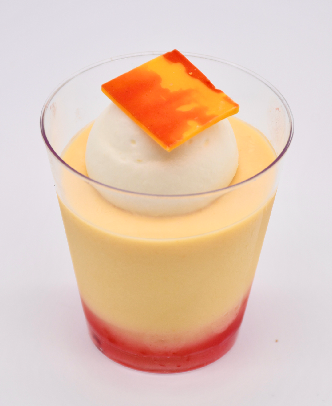 passion fruit in a clear cup with a piece of orange on top