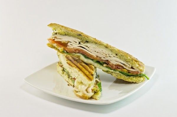 A sandwich is cut in half on a white plate