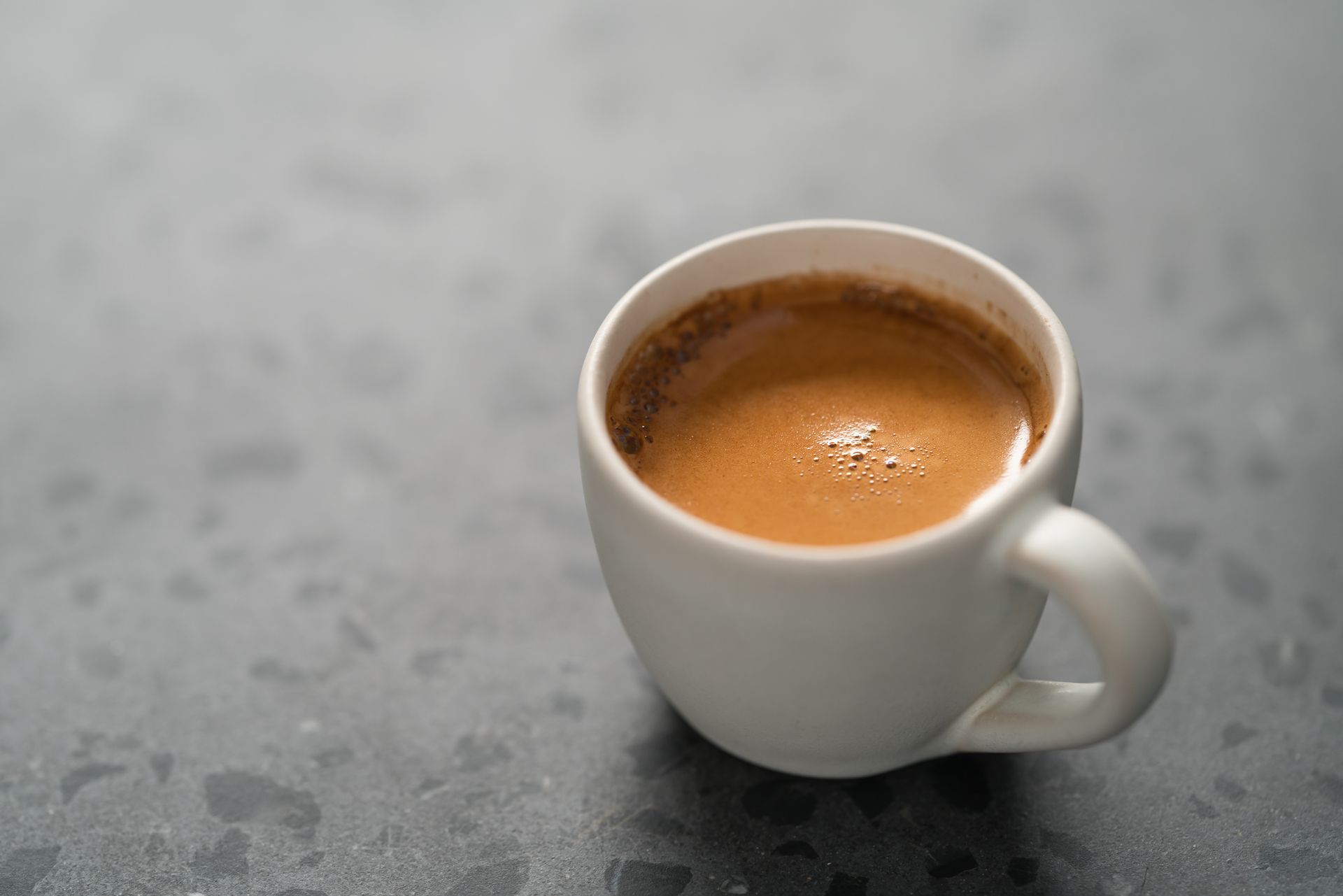 A close up of a cup of coffee on a table.