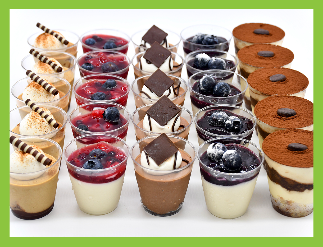 A variety of desserts in plastic cups on a table
