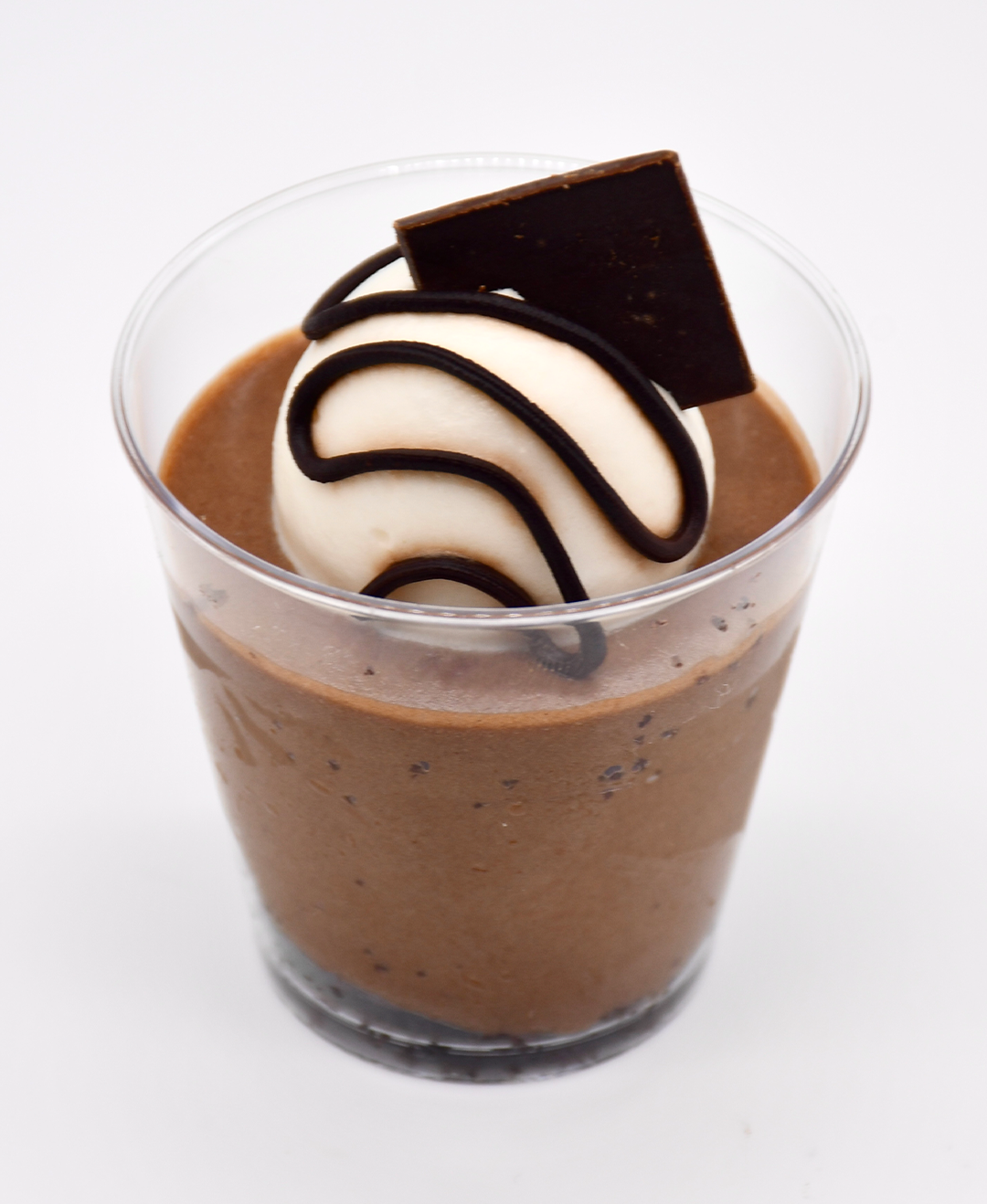 A cup of chocolate mousse with whipped cream on top