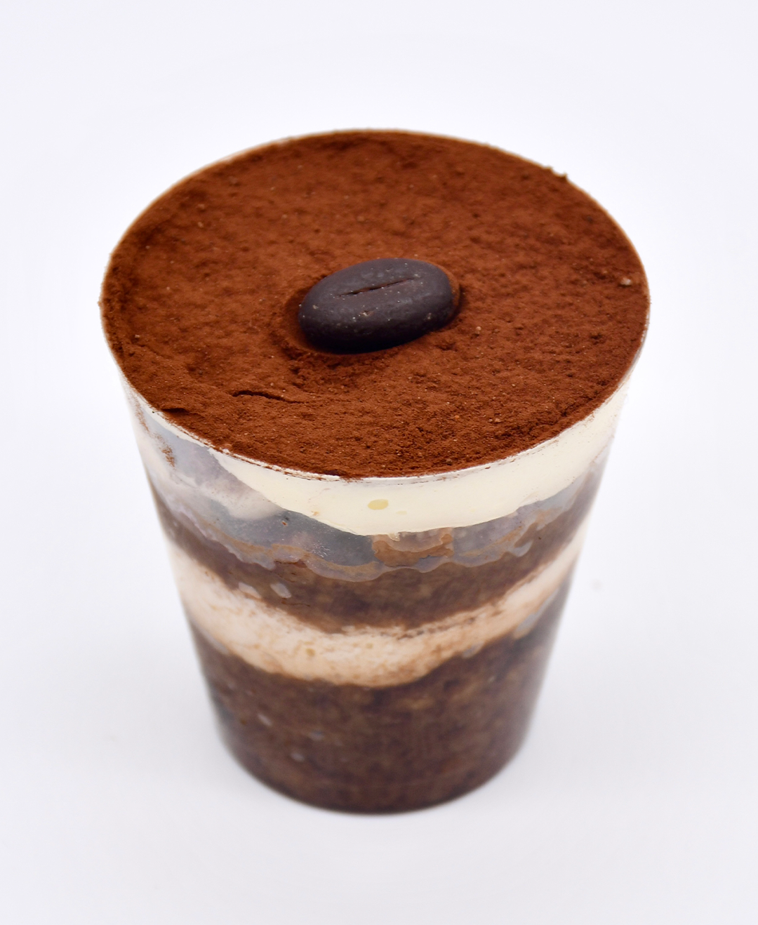 A cup of tiramisu with a coffee bean on top