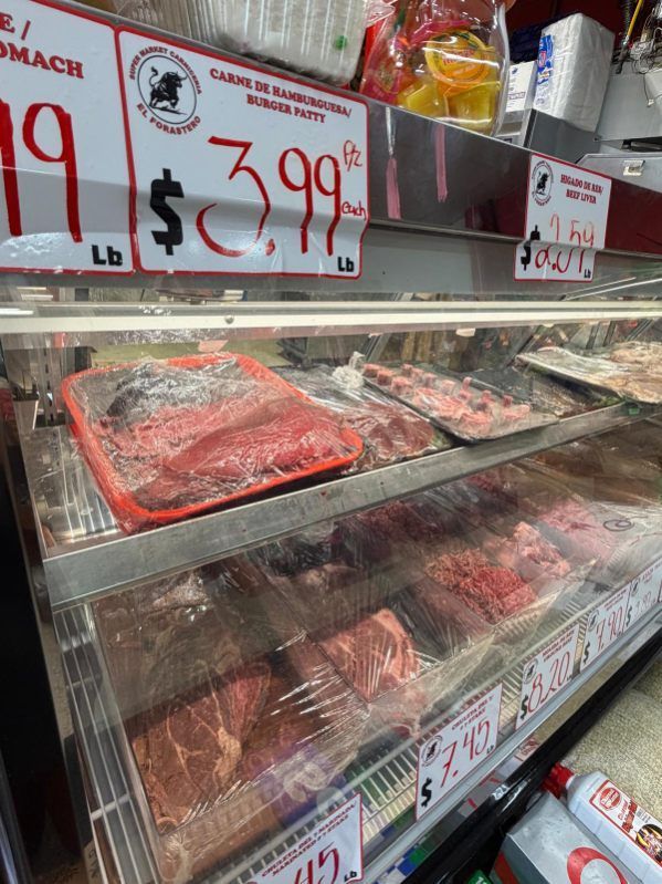 Seafood counter with trays of fish and red price signs, including a $3.99/lb label.