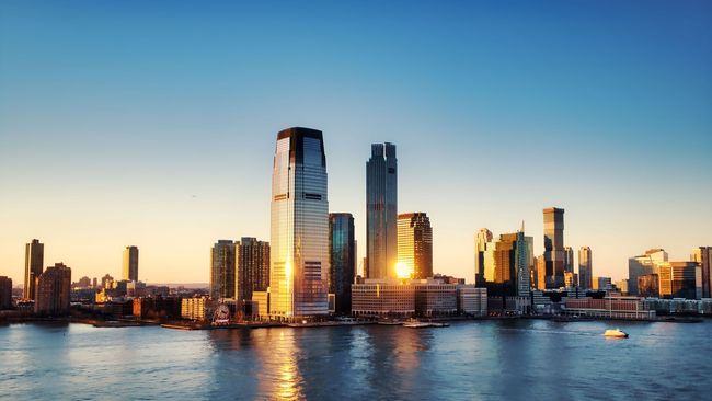 Chicago skyline and lakefront beach at sunset, with tall buildings along the waterfront.