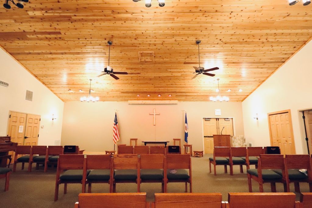 A church with rows of wooden benches and a podium