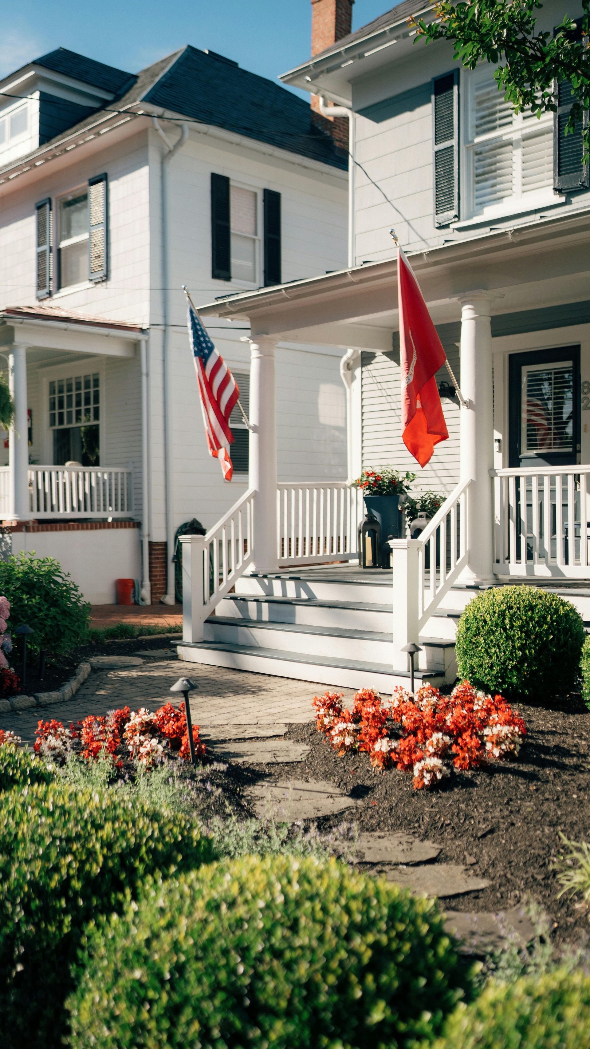 A white house with an american flag on the porch.