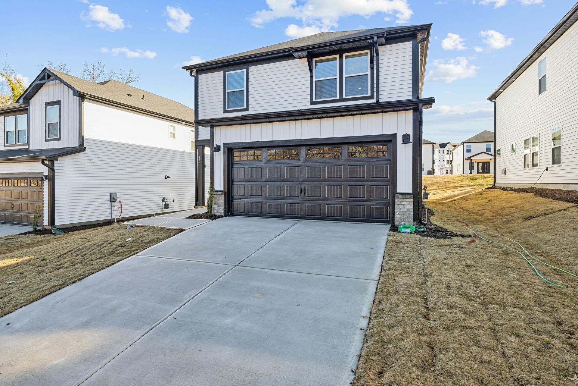 A house with a garage and a concrete driveway in front of it.