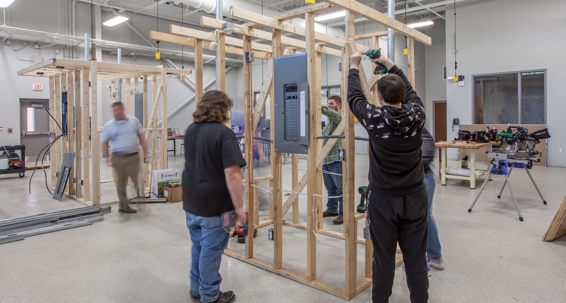 A group of people are working on a building in a factory.