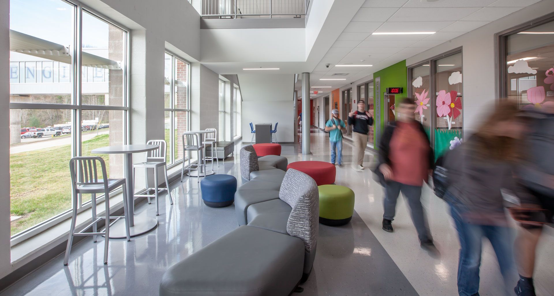 A group of people are walking down a hallway in a school building.