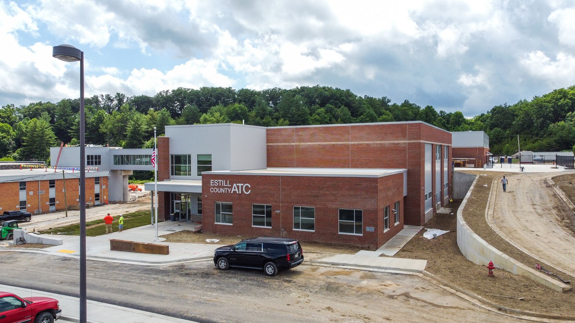 An aerial view of a building under construction with a red truck parked in front of it.