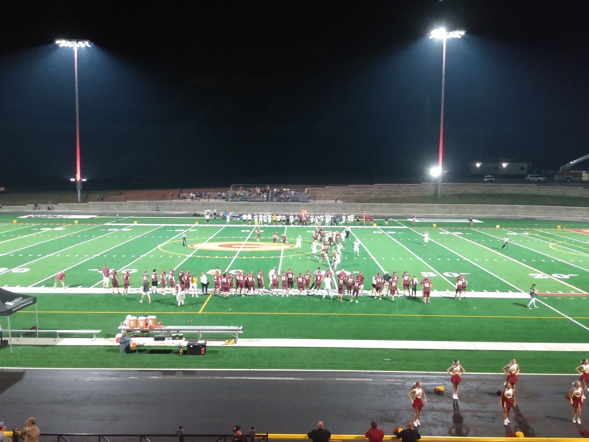 A football game is being played in a stadium at night