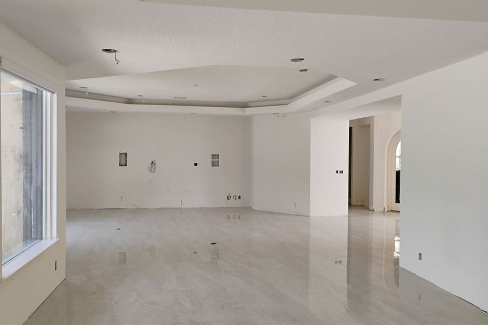 Empty white modern living room with glossy tile floors and arched doorway