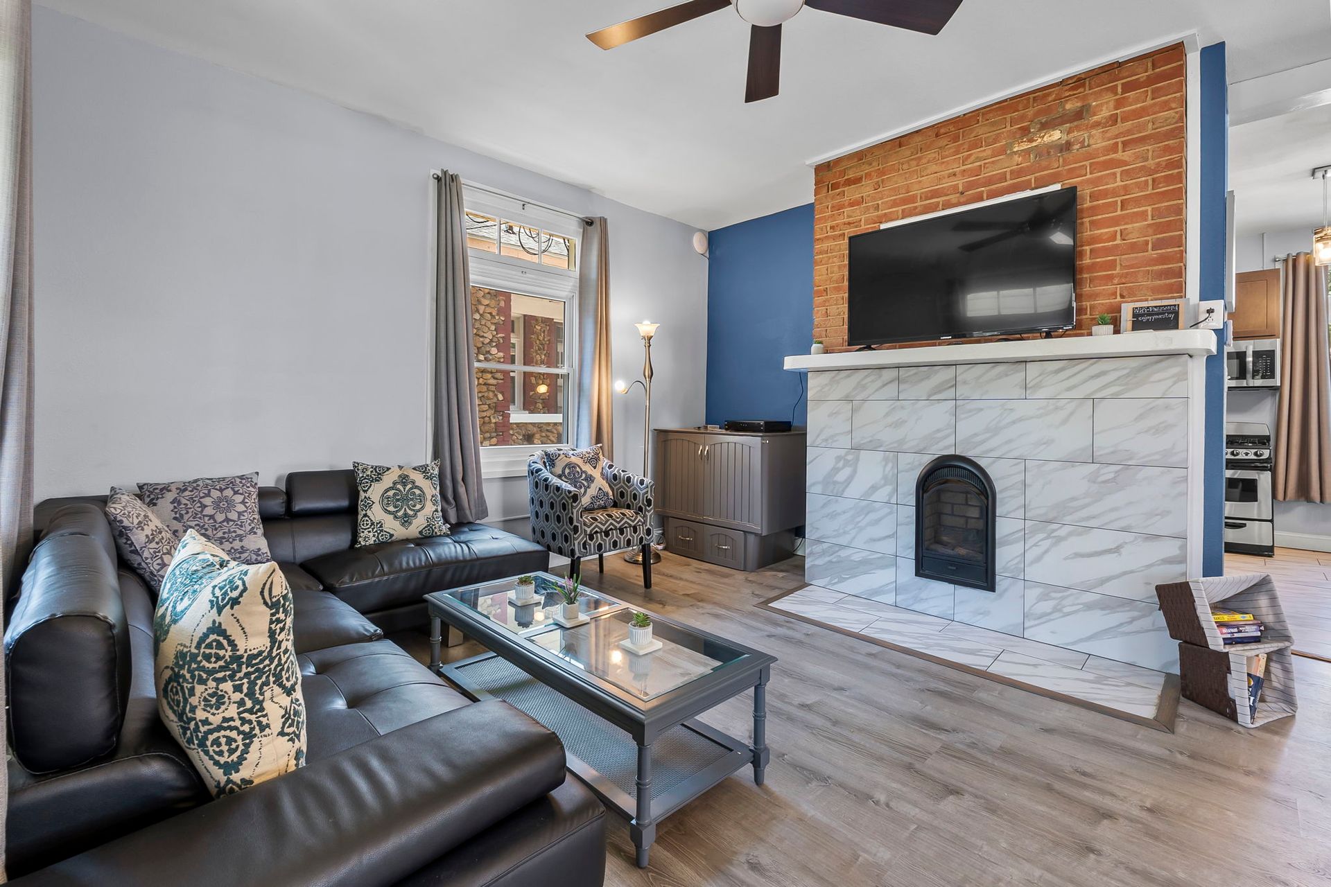 A living room with a couch , chairs , coffee table and fireplace.