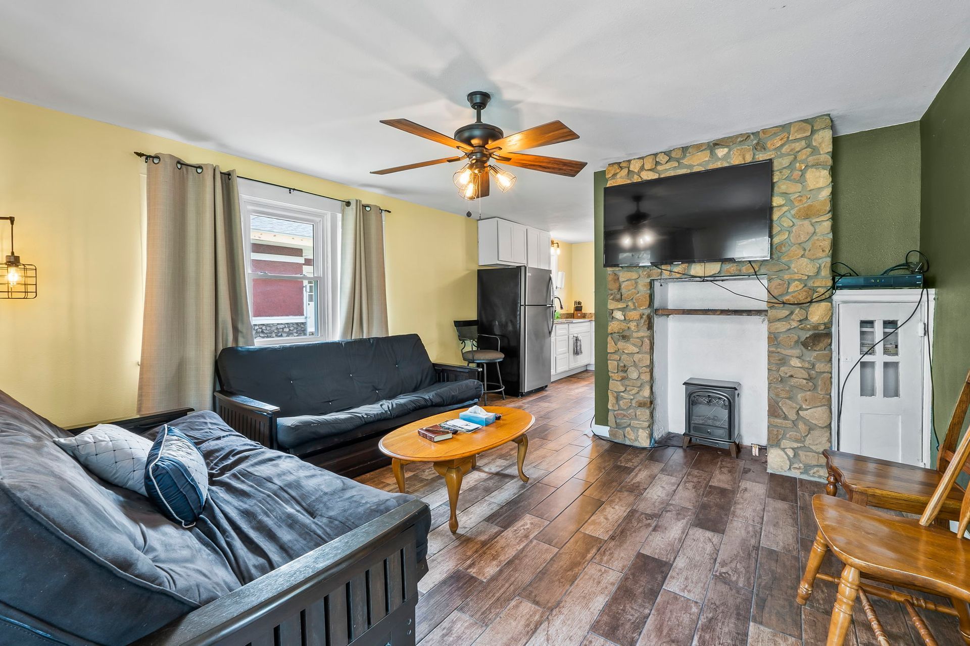 a living room with a couch , table , chairs , fireplace and television .
