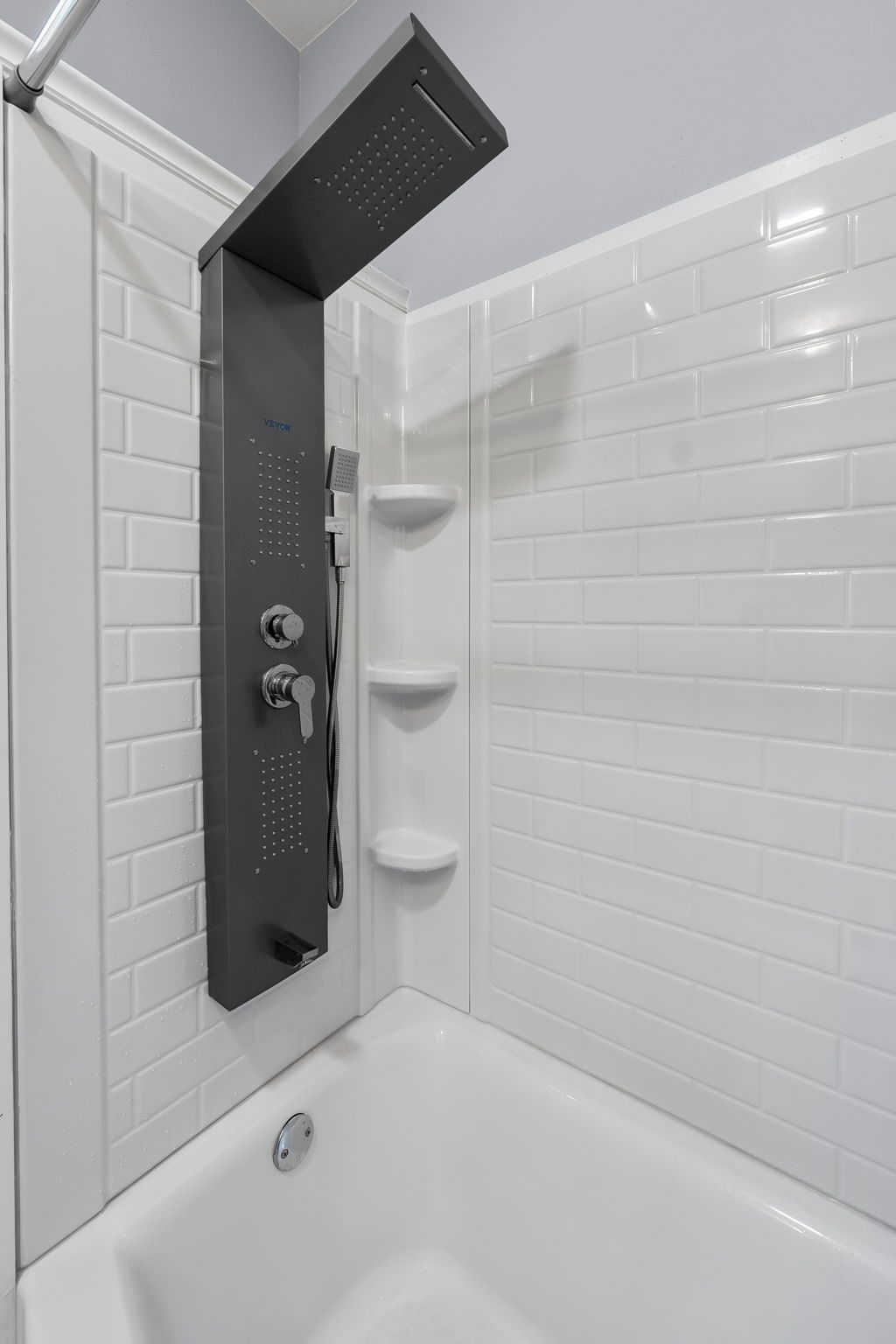 A bathroom with a bathtub and a shower head.