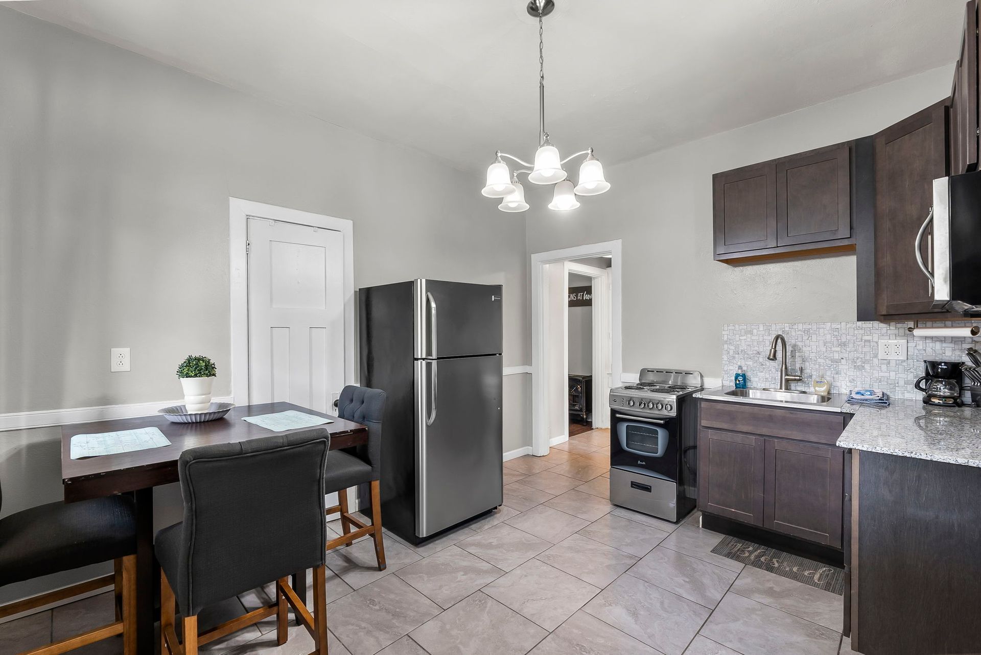 a kitchen with a refrigerator , stove , table and chairs .