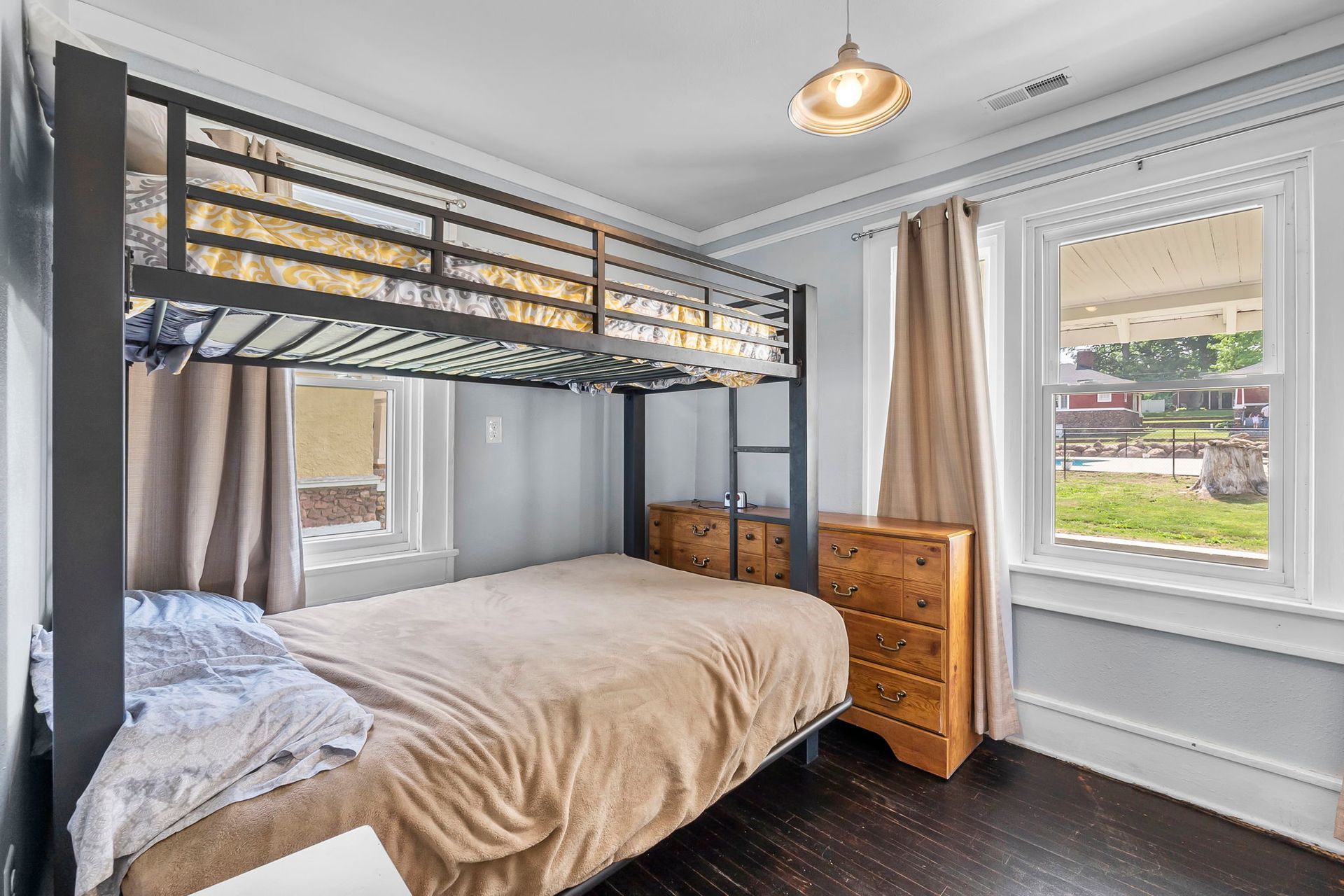 A bedroom with a bunk bed and a dresser.