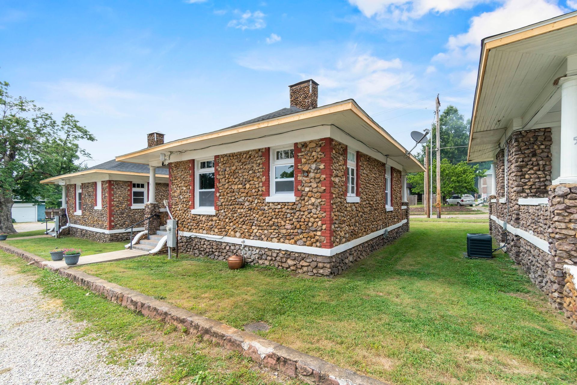 a row of brick houses are sitting next to each other on a lush green lawn .