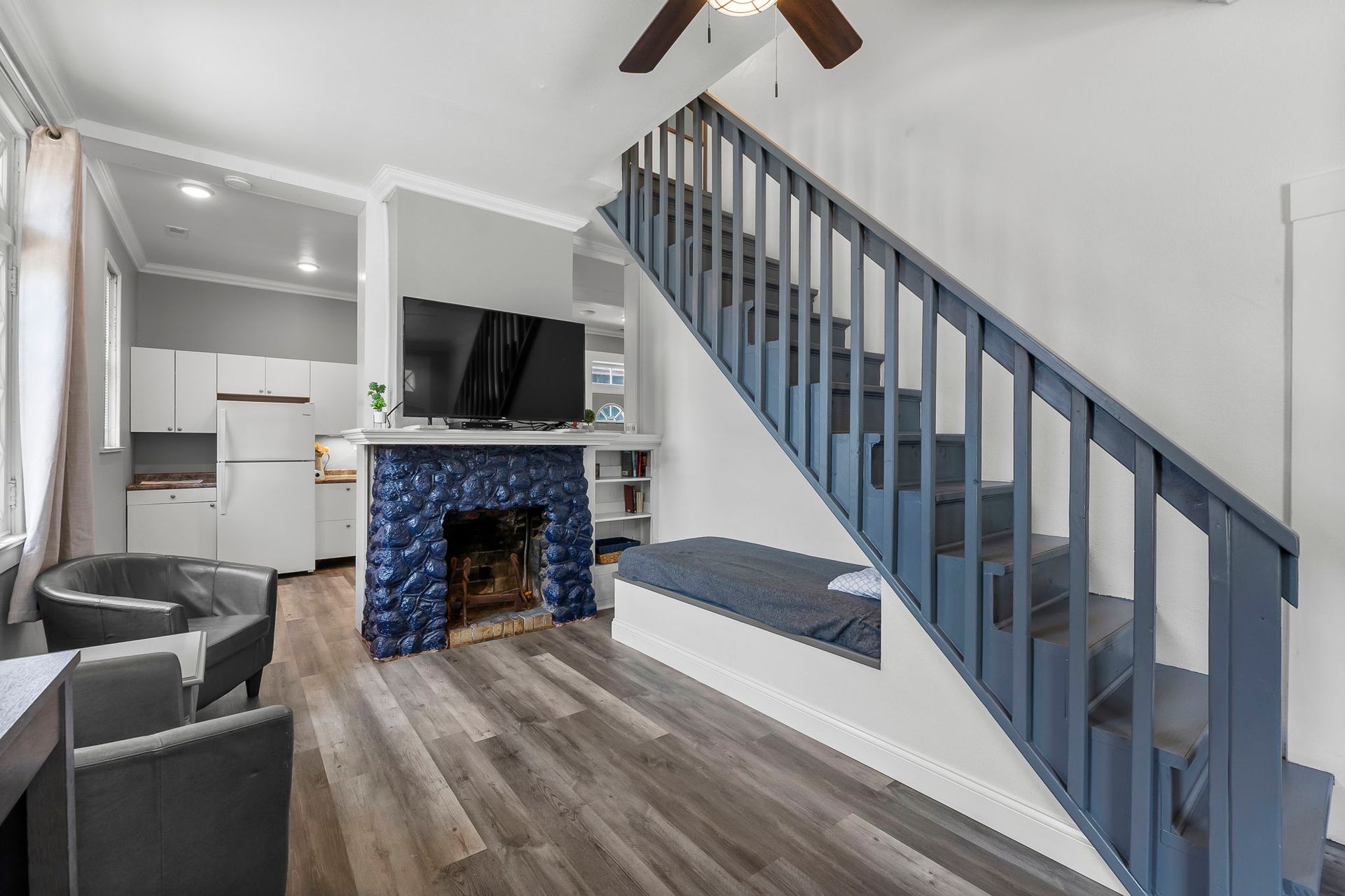 a living room with stairs leading up to the second floor and a fireplace .