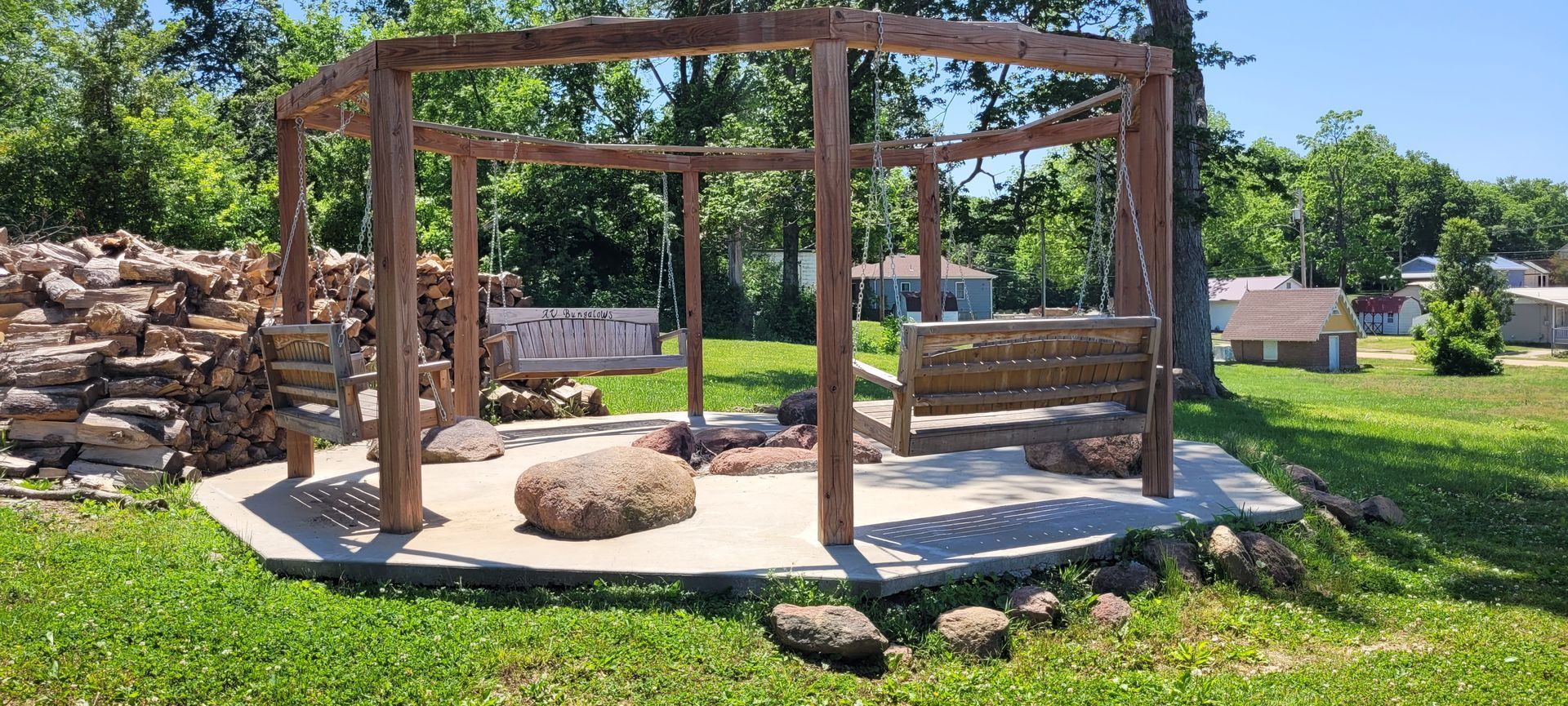 A wooden gazebo is sitting in the middle of a lush green field.