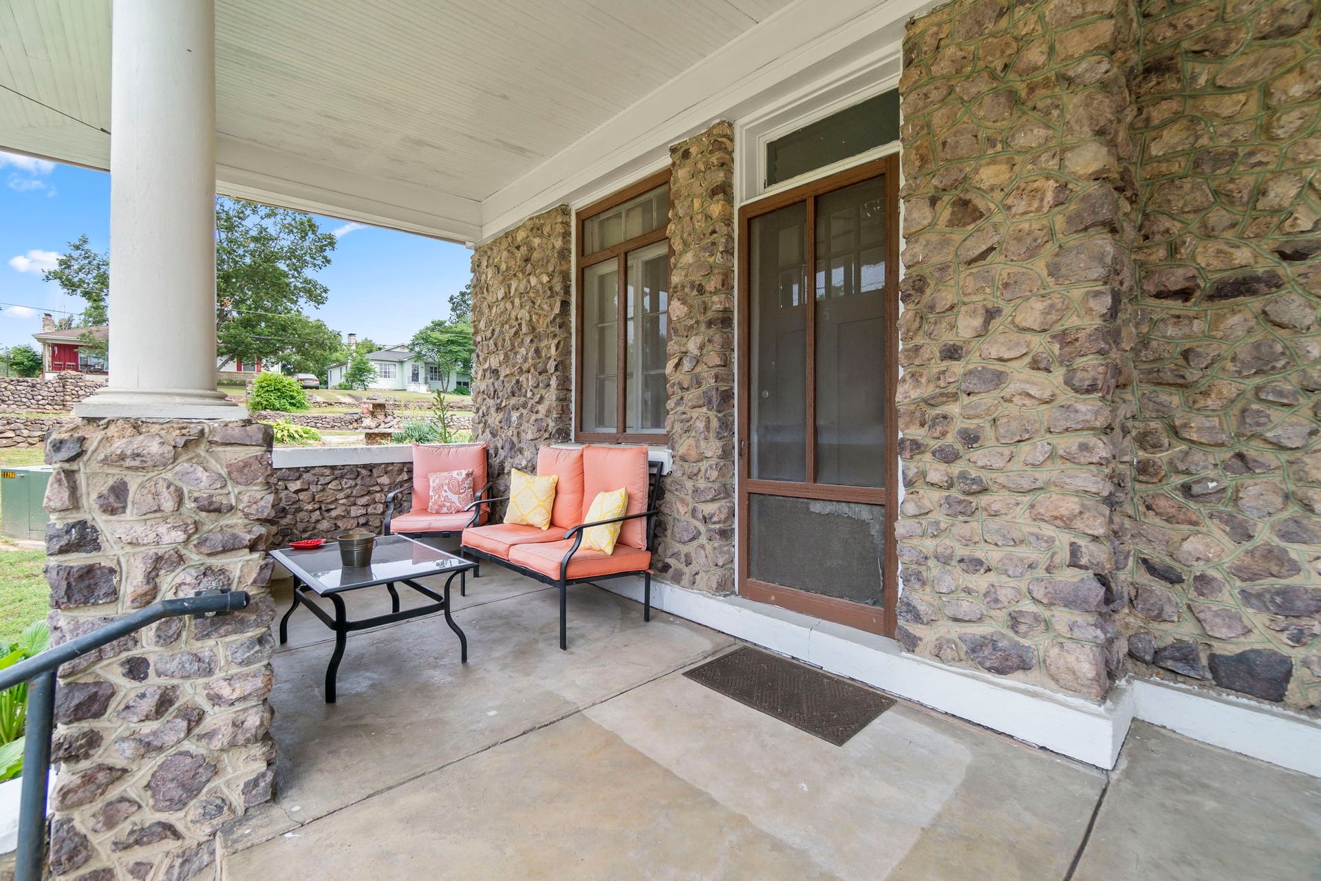 there is a porch with a couch and a table on it .