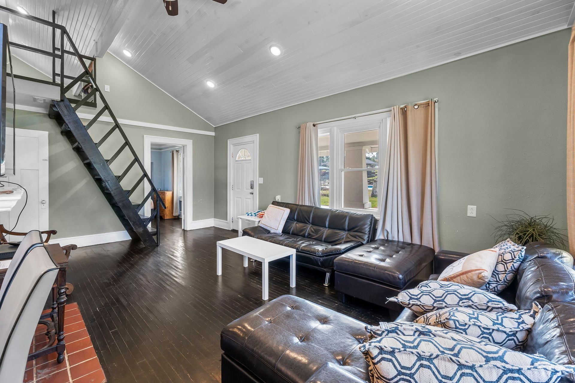 A living room with a staircase leading up to the second floor.