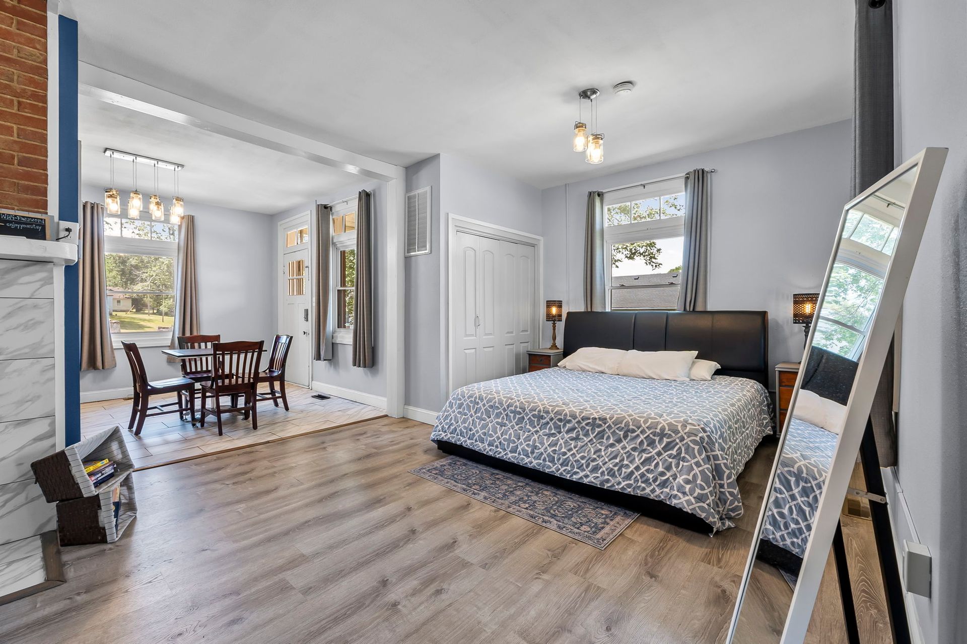 A bedroom with a large bed and a mirror.