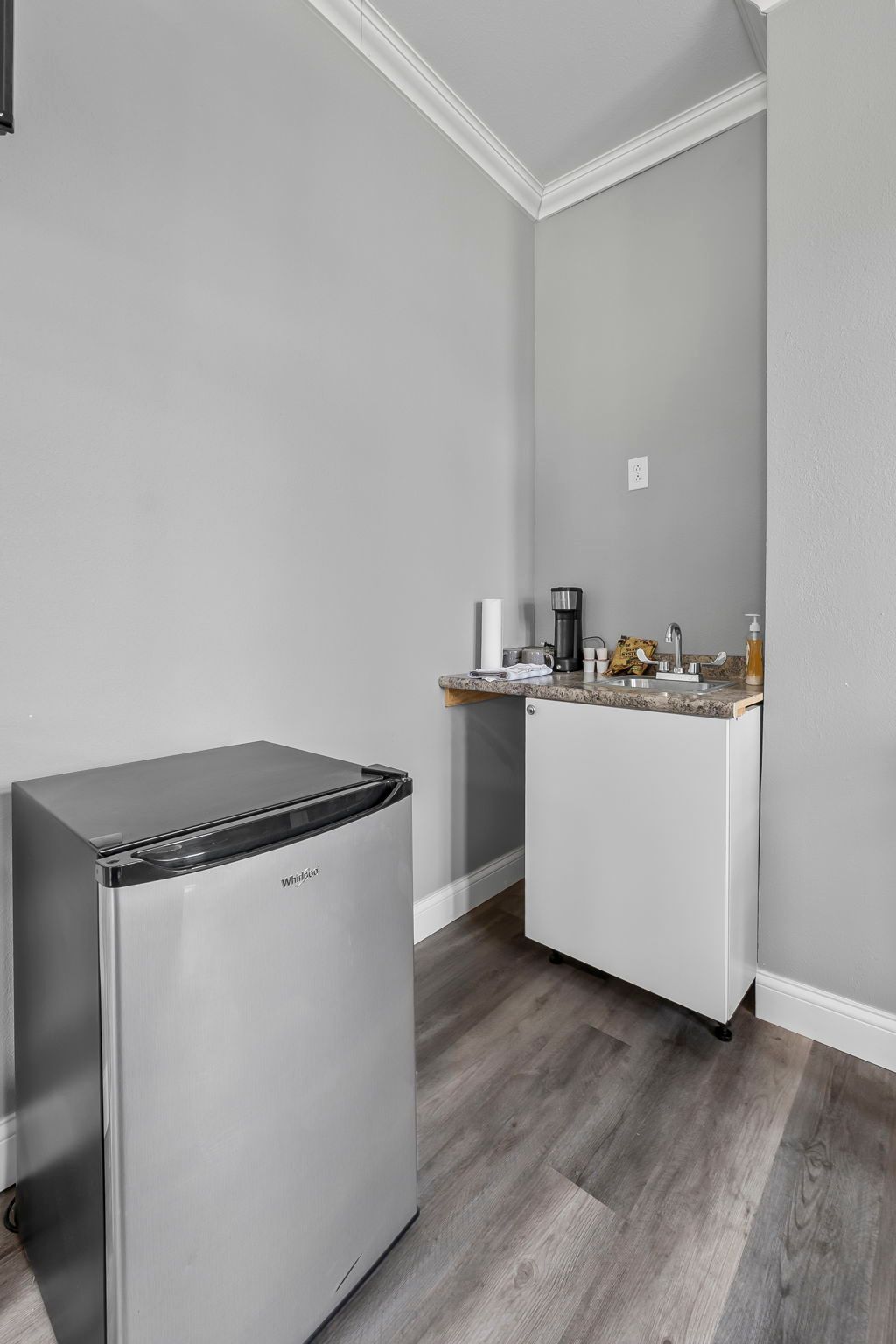 there is a small refrigerator in the middle of the room .