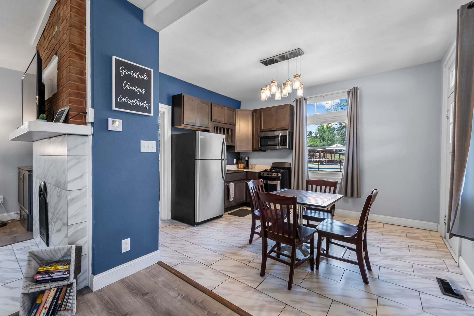 A kitchen with a table and chairs and a refrigerator.