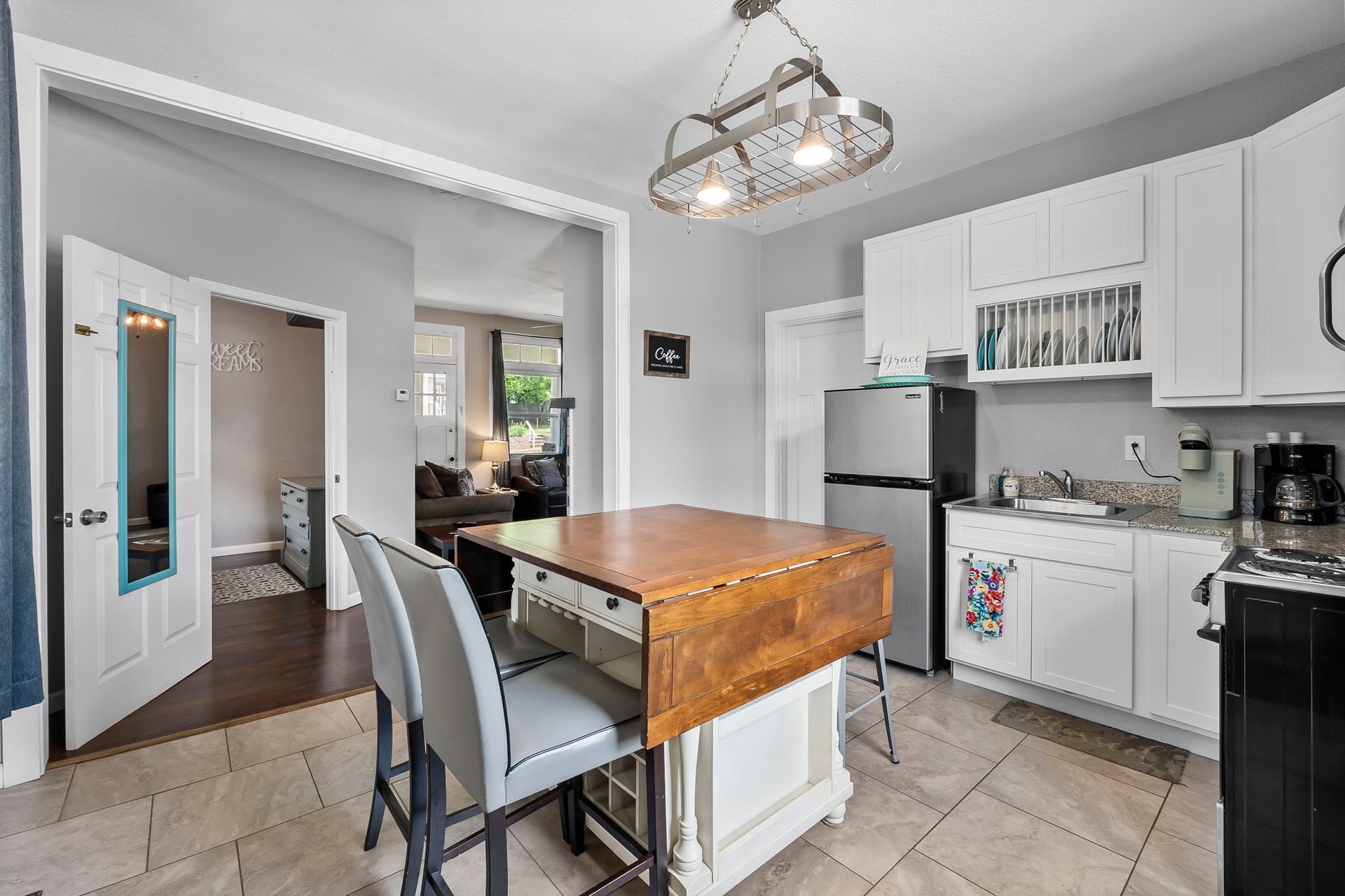 A kitchen with a table and chairs and a refrigerator.