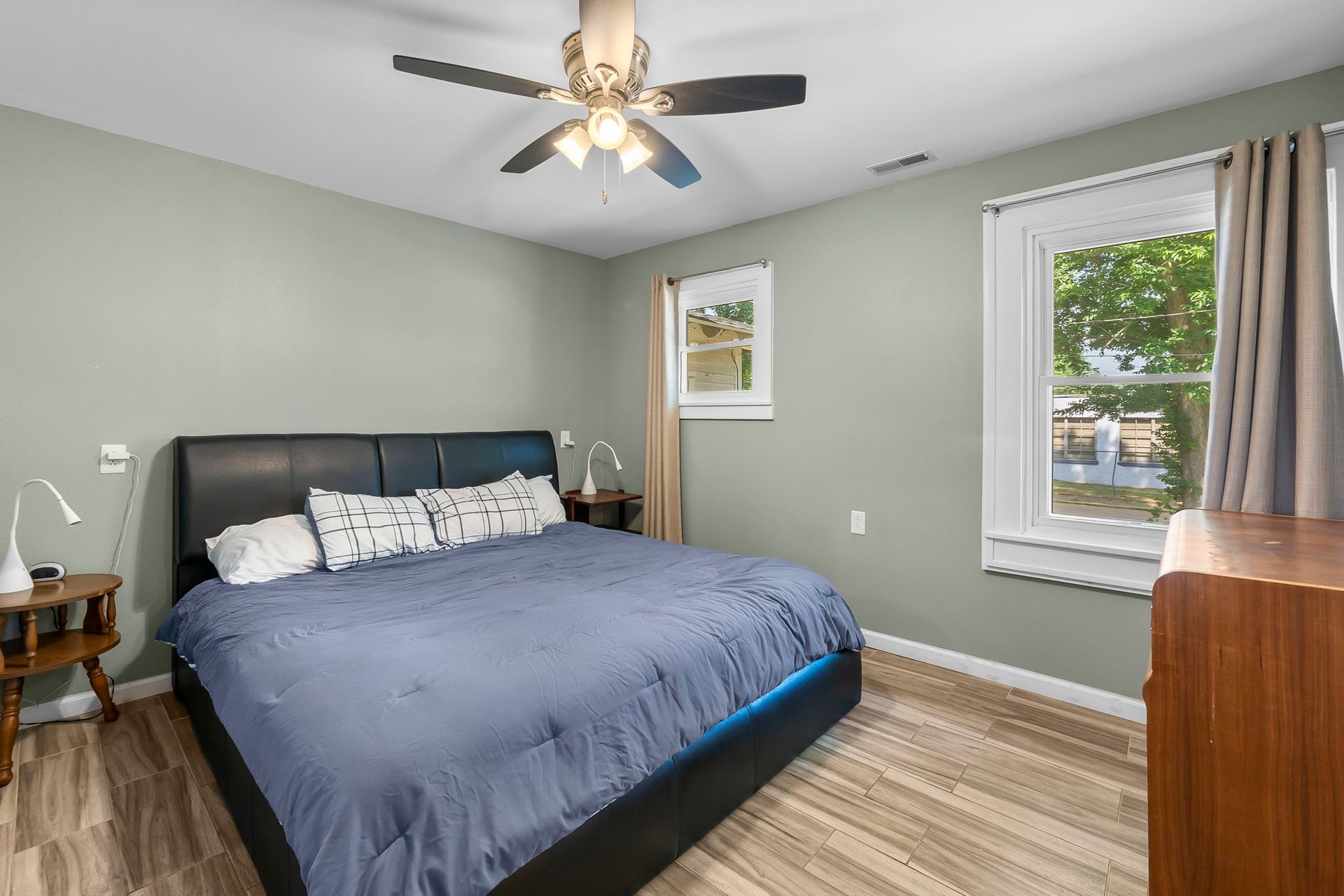 A bedroom with a king size bed and a ceiling fan.