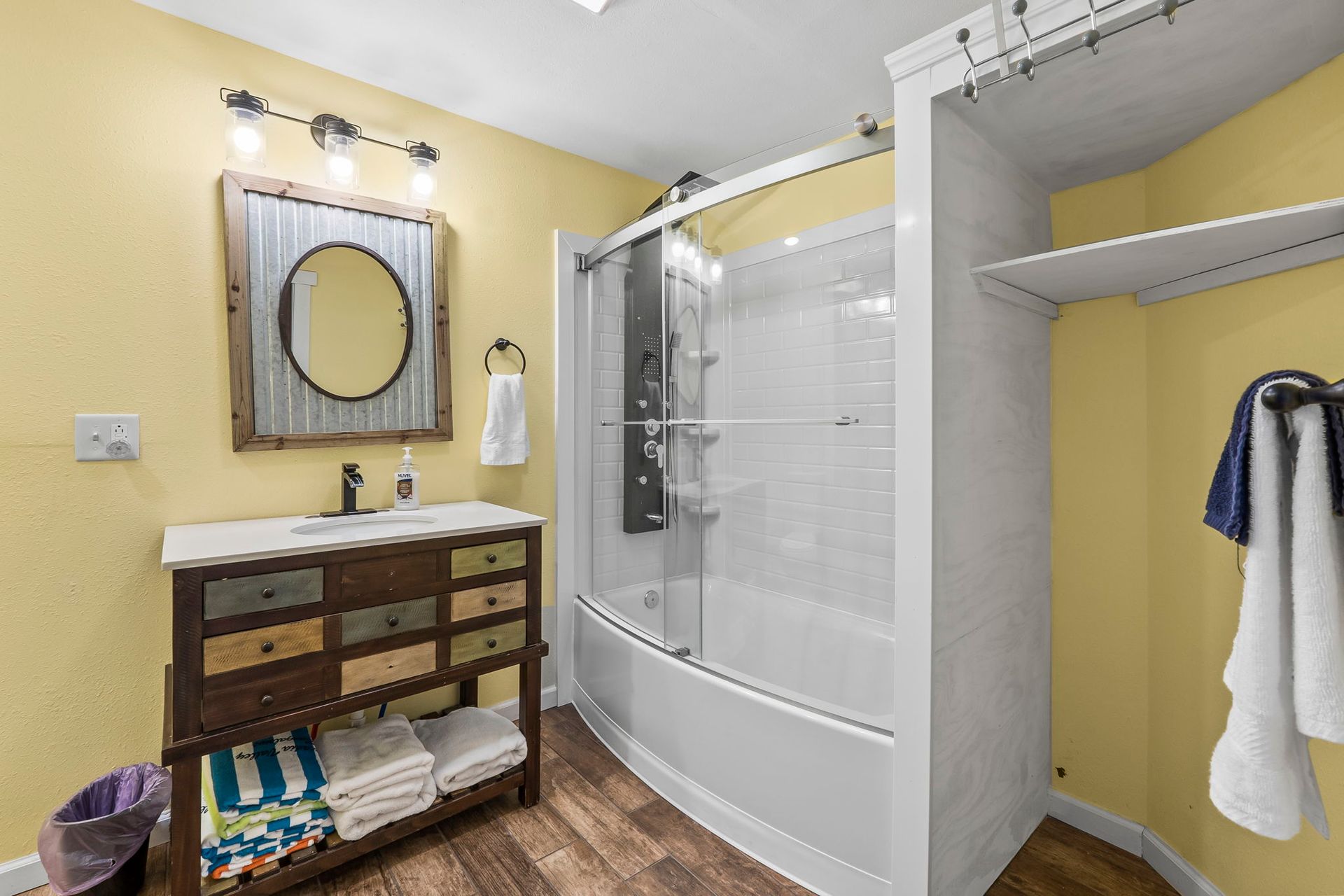 a bathroom with a sink , tub , shower and mirror .