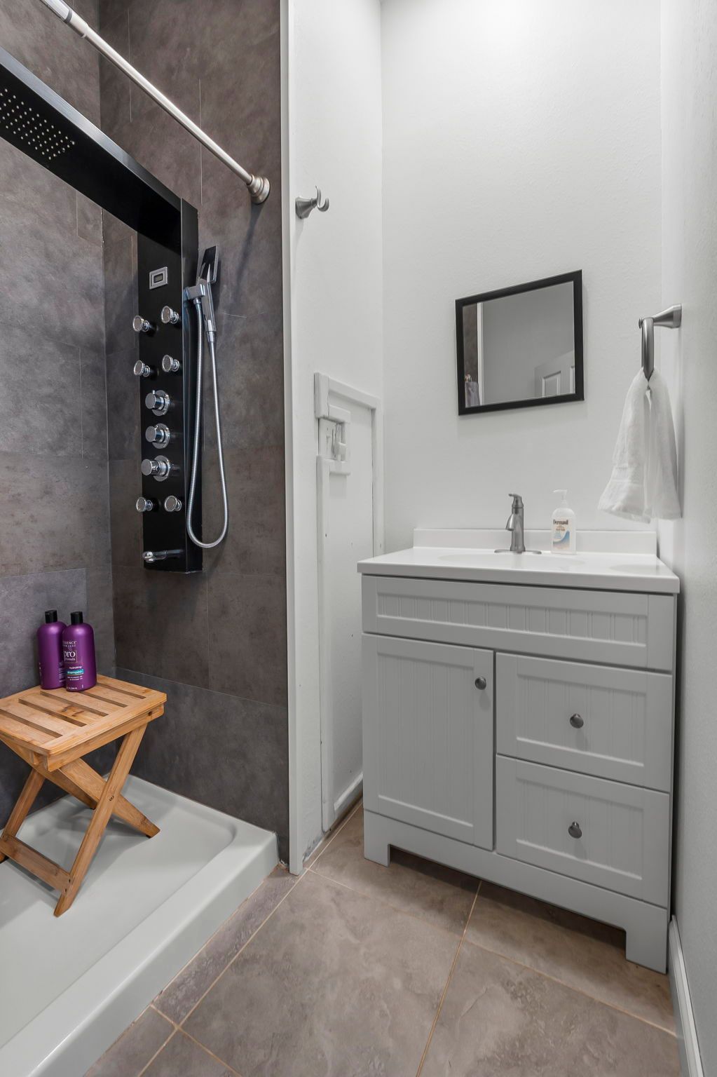 a bathroom with a sink , shower and mirror