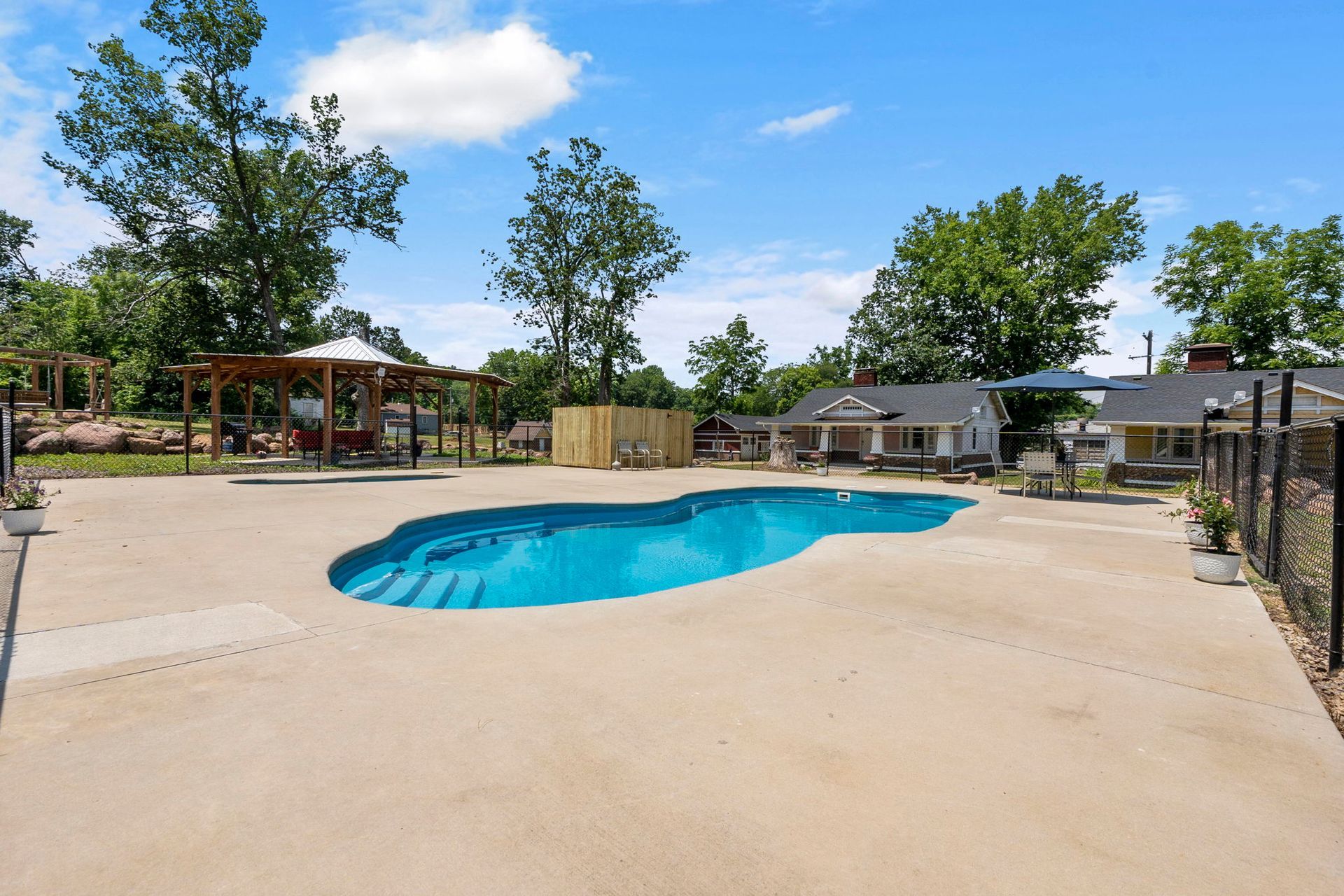 There is a large swimming pool in the middle of the yard.