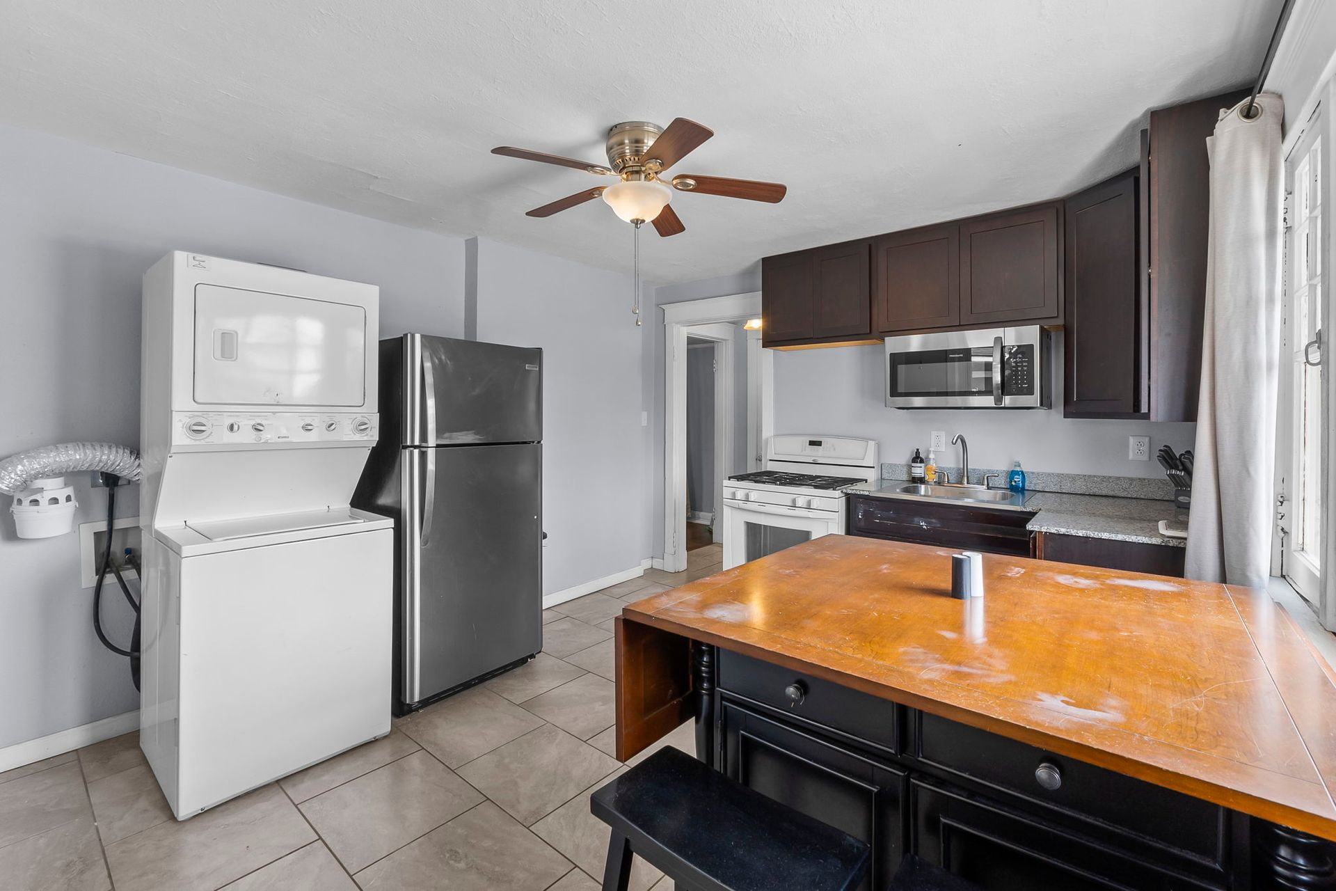 a kitchen with a refrigerator , washer and dryer , and a table .