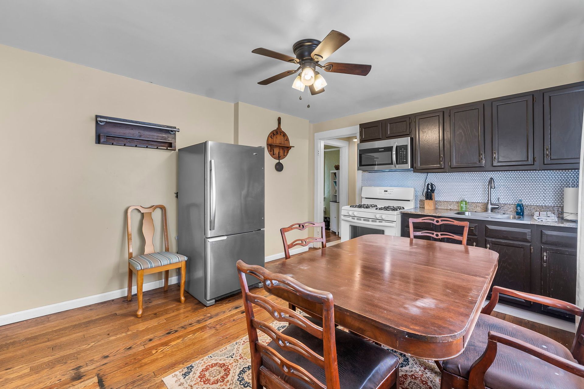 a kitchen with a table and chairs and a ceiling fan .