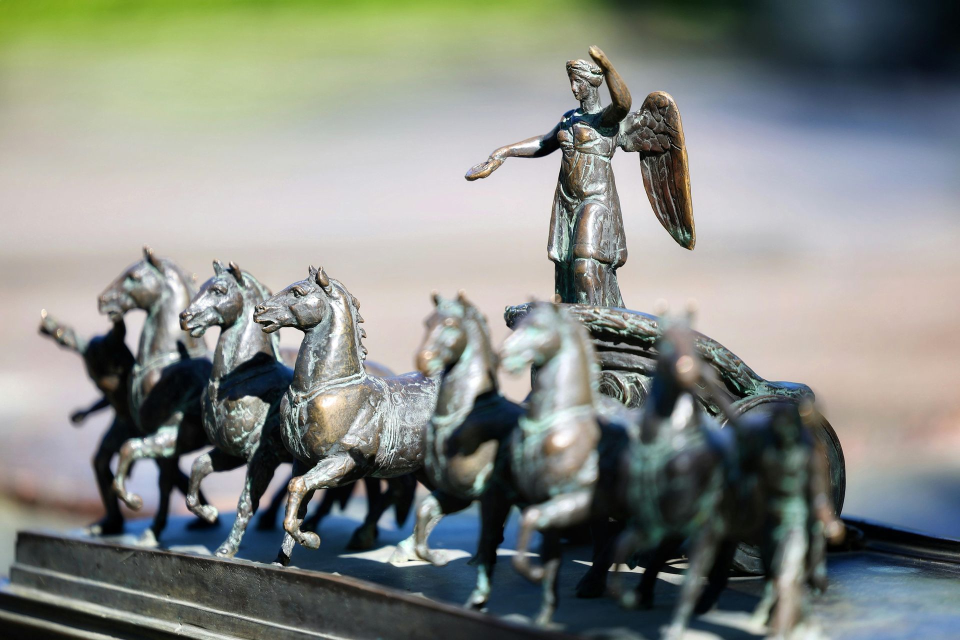 A statue of a man standing on top of a chariot pulled by horses.