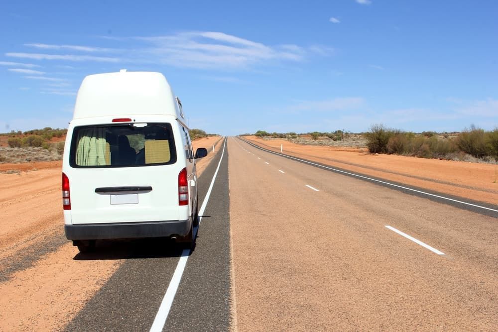 A White Van is Parked on the Side of the Road  - Charter Transport in Darwin, NT